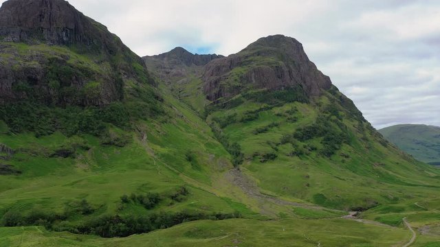 Aerial view of picturesque landscape of Glen Coe, scenic valley in Highlands of Scotland, lush green hills - panorama of Scotland from above, United Kingdom, Great Britain, Europe
