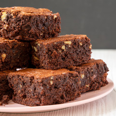 Homemade chocolate brownies on a pink plate, side view. Close-up.