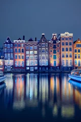 Rolgordijnen Old brick houses on the canal in Amsterdam at night © badahos