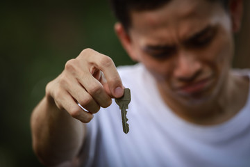 泣きながら鍵を渡す男性