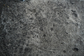 Texture of an old cracked concrete wall. Background image of a worn gray concrete surface