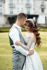 Young loving couple hugging and dancing on the green grass. Beautiful and happy woman and man gently touch each other. Beautiful couple in love. girl in the dress and the guy in the shirt.