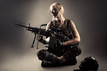 Fototapeta na wymiar attractive blond woman with machine gun in hands