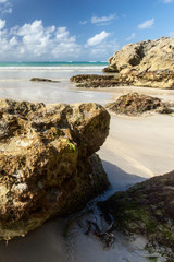 Wild beach in the sandy bay of the blue tropical sea.
