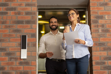 Positive delighted young people going to their workplace