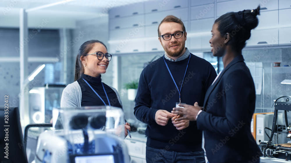 Wall mural multi ethnic team of male and female leading scientists discussing innovative robotics technology. t
