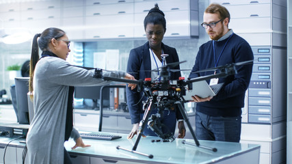 Multi Ethnic Team of Young Female and Male Engineers Working on Modern Drone Prototype. They're in...