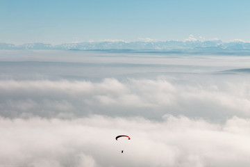 paraglider in the sky against mountains