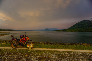 Fototapeta premium Purwakarta, West Java, Indonesia (03/30/2018) : The rider is touring with his motorcycle through the Jatiluhur Dam side which is commonly called Parang Gombong