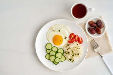 Fototapeta na wymiar Healthy breakfast - fried egg with cherry tomatoes and cucumber on light white background, fodmap dash diet, gluten free, top view closeup copy space