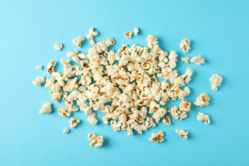 Flat lay composition with popcorn on blue background, copy space