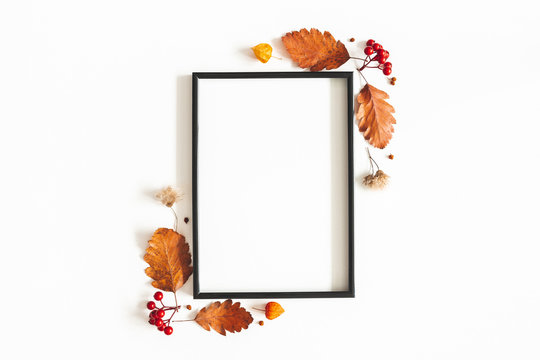 Autumn composition. Photo frame, flowers, leaves on white background. Autumn, fall, thanksgiving day concept. Flat lay, top view, copy space