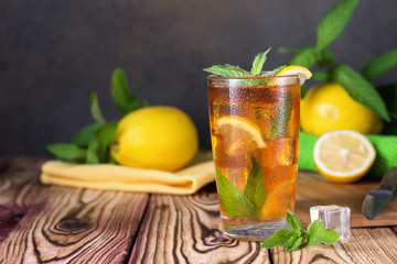 Glass of iced tea with mint and lemon. Cold drink. Rustic style
