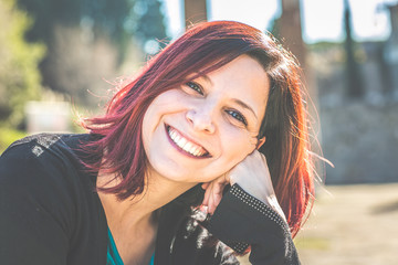 Portrait of beautiful young woman smiling and looking away at park.