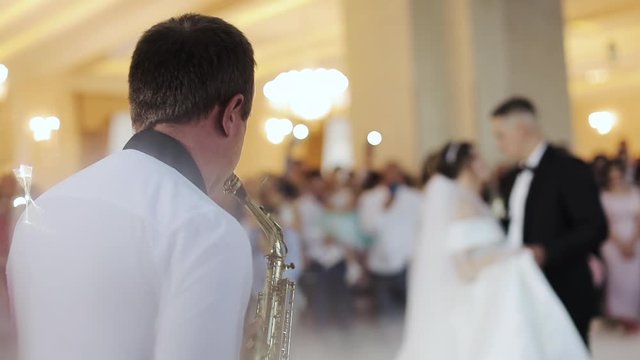 Saxophonist play on golden saxophone. Live performance. First dance at the wedding party