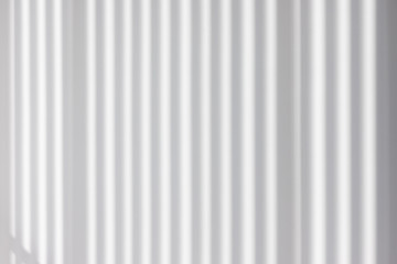 Obraz premium light and striped shadow on white concrete wall. interior design sun protection from wooden batten. house saving energy concept. vertical abstract shadow pattern background.