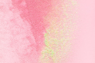 Many multi-colored spangles are scattered on a pink background.  View from above.  Place for text.
