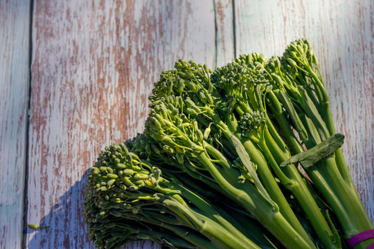 Bunch of fresh broccolini on a wooden table background. Healthy eating. Cooking ingredient. Hybrid of broccoli and chinese broccoli
