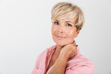 Portrait closeup of joyous middle-aged woman with short blond hair smiling at camera
