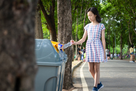 Asian Child Girl Hand Holding Plastic Bottle,putting Plastic Water Bottle In Recycling Bin,tourist Woman Hand Throwing Garbage In A Trash Bin On Street At Park,environmental Protection,global Warming 