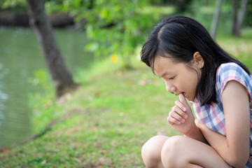 Asian child girl feeling stressed,female worried bites finger nails ,girl patient with nervous expression,nail biting,anxious with hand on mouth biting her nails,fear,anxiety problem,mental health