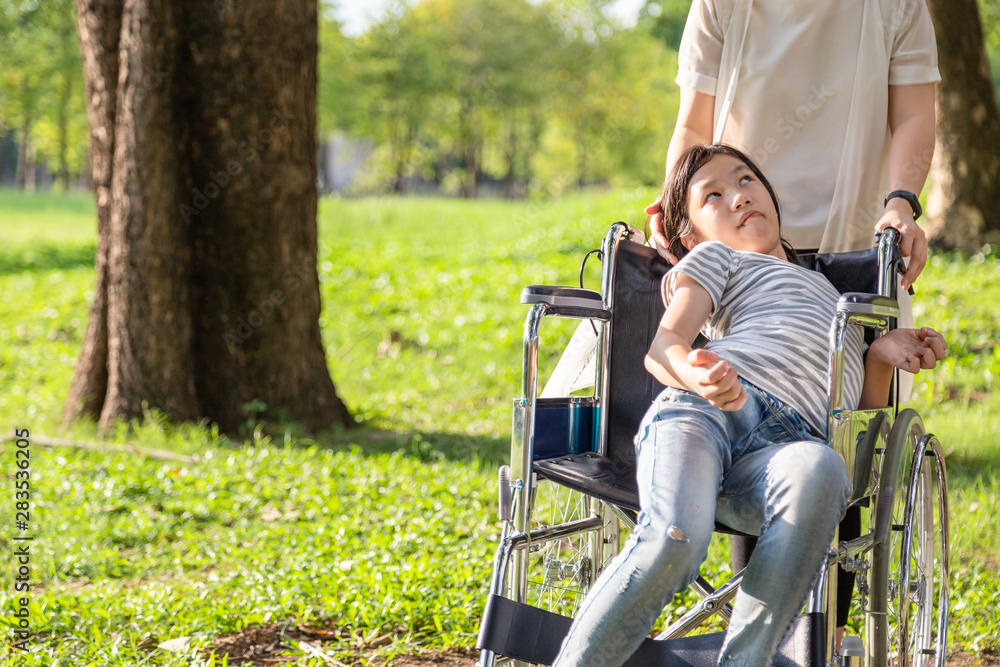 Wall mural sick child girl with cerebral palsy in wheelchair outdoor park or daughter suffering from seizures,i