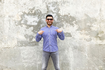 This is me. Portrait of happy handsome bearded young man in checkered blue shirt, sunglasses...