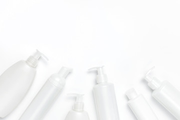 White cosmetic bottle containers on white background top view flat lay with space for text. Cosmetics SPA branding mock-up, Natural organic beauty product concept, Minimalism cosmetics style