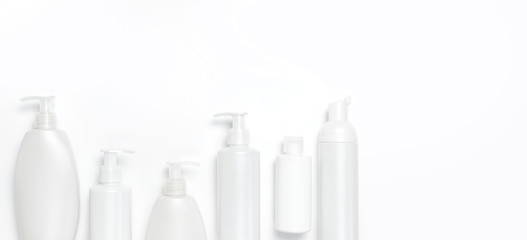 White cosmetic bottle containers on white background top view flat lay with space for text. Cosmetics SPA branding mock-up, Natural organic beauty product concept, Minimalism cosmetics style