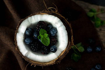 blackberries and blueberries in a coconut close up