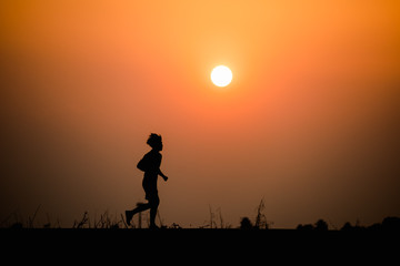 Fototapeta premium Silhouette man running on sunset background
