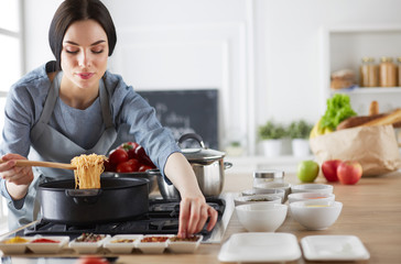 Cooking woman in kitchen with wooden spoon