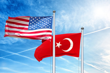 usa and turkish national flag waving against cloud blue sky side view of natural color of united states of america us and republic of turkey state symbols isolated for design copy space template