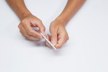 Woman hands filing nails, beauty hand treatment on white background