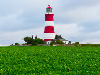 The red and white banded Happisburgh lighthouse against a cloudy late evening sky in Norfolk
