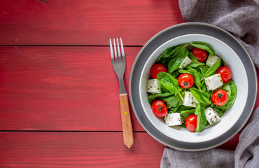 Salad with tomatoes, spinach and cheese. Italian cuisine. Healthy eating. Diet.