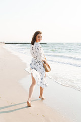 Cheery positive happy young beautiful woman at the beach walking in a beautiful sunny morning.