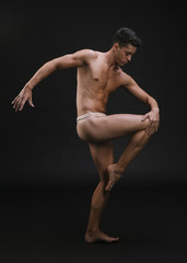 Fototapeta na wymiar Muscular dancer stretching leg