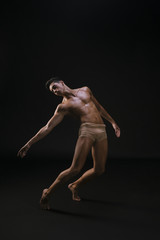 Naked athletic man standing and extending hand