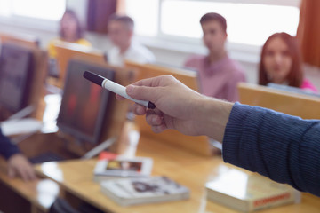 Male professor explain lesson to students and interact with them in the classroom.Helping a students during class.