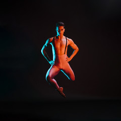 Confident male ballet dancer performing in spotlight