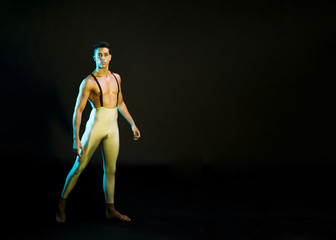 Expressive male ballet dancer performing in spotlight