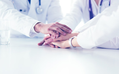 Team of doctors putting hands together, closeup