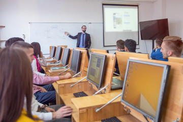 Male professor explain lesson to students and interact with them in the classroom.Helping a students during class.
