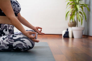 Fototapeta premium woman sitting on the floor and doing meditation at yoga class