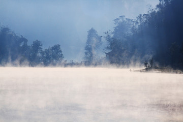 Beautiful landscape heaven of mist and fog over the lake and sunrise shining with blue sky reflection on the water surface at Hill tribe village on mountain in Thailand