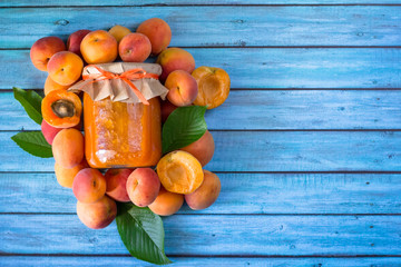 Organic homemade apricot jam on vibrant  blue wooden table. Healthy prepared food. Copy space.
