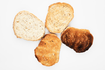 Appetizing slices of bread of different roasting. White background.