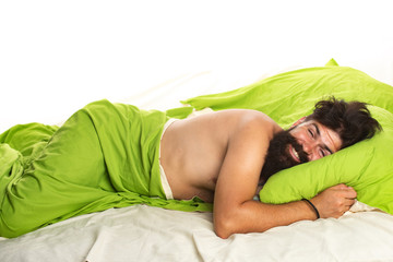 Young man sleeping in bed with pillows at home. Handsome man in bed. sleeper. Wake up Sleepy.