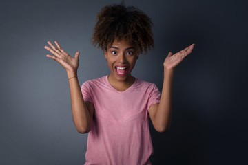 Achievement, success concept. Cheerful African American female raising her hands up, having eyes full of happiness rejoicing her great achievements. Attractive caucasian female dressed formally.